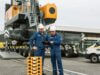 Titelbild für die Liebherr-Referenz zur Entwicklung der App für Kundenservice-Verträge: 2 Liebherr-Monteure blicken auf eine Tablet, im Hintergrund ein Kran von Liebherr