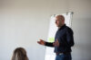 IT-Change-Management-Berater in Anwenderschulung vor Whiteboard mit Publikum