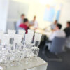 Referenzbild | CRM-Lösung für C. Gerhardt Analytical Systems: Im Vordergund - Laborgefäße, im Hintergrund - ein Team-Meeting